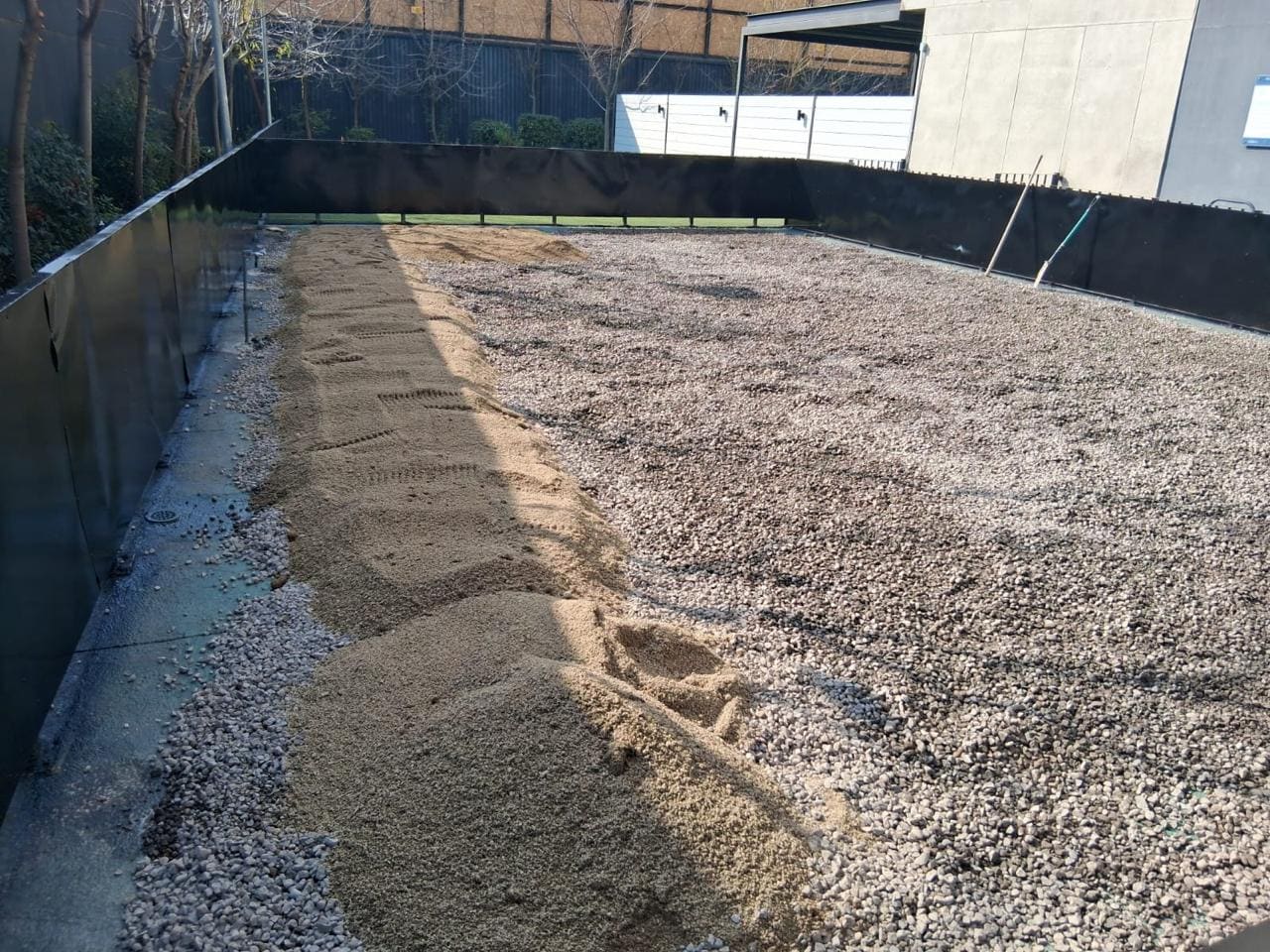 Terreno preparado con base de árido compactado durante el reacondicionamiento de caniles