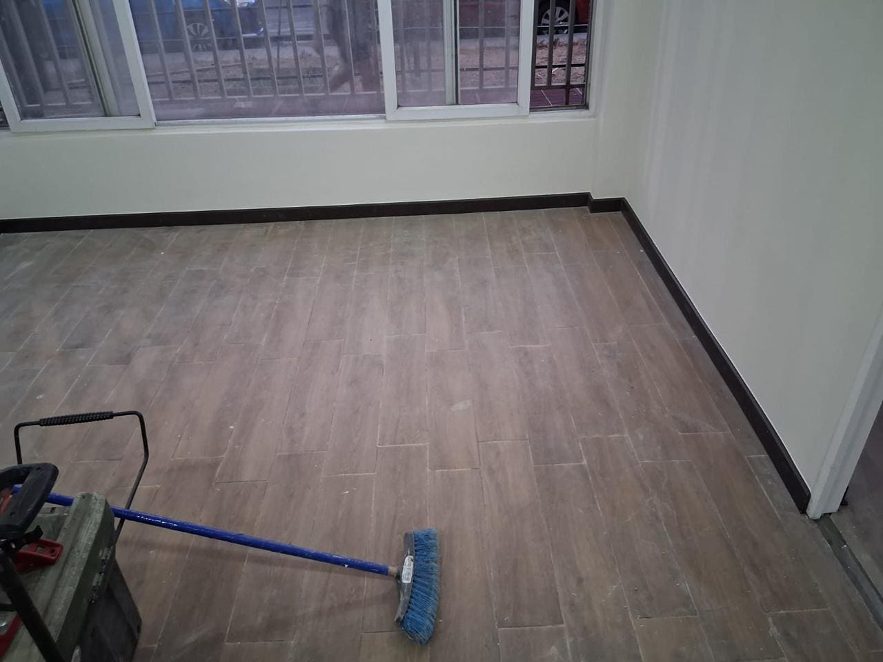 Recinto con piso flotante recién instalado durante la limpieza final de entrega de obra